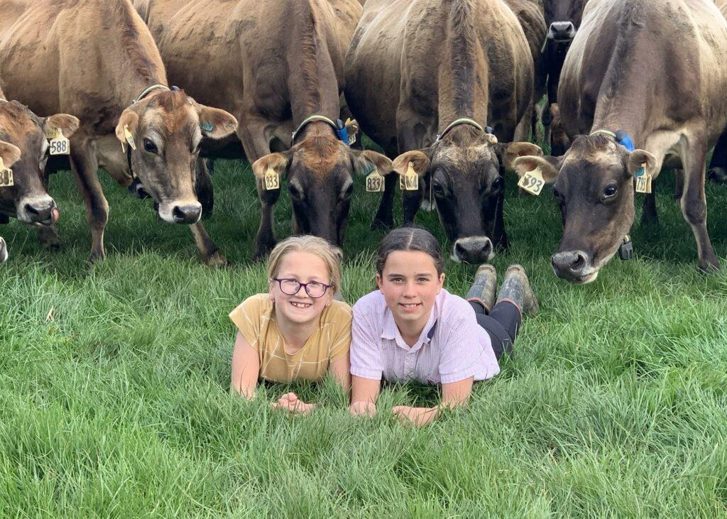 L-R: Georgia and Ashley Guy provide the entertainment for their parent’s cows in this great family memory. Photo supplied.